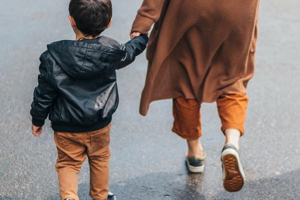 Mamma och pojke på väg till skolan.